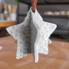 Load image into Gallery viewer, Person holding a star-shaped object with a textured surface
